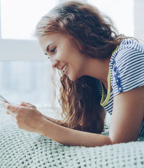 Woman smiling while checking her phone